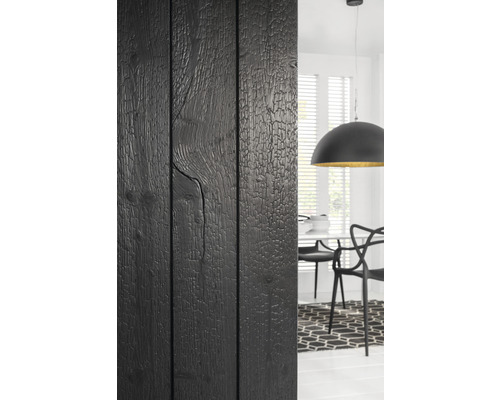 Schwarze Holzwand neben Essbereich mit Tisch, Stühlen und Lampe
