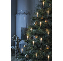 Arbre de Noël avec bougies et décorations, cheminée en arrière-plan