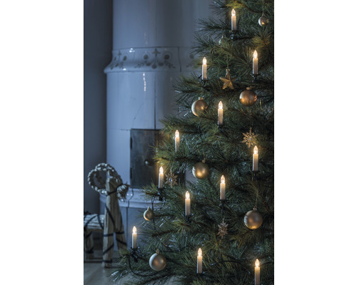 Arbre de Noël avec bougies et décorations, cheminée en arrière-plan