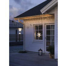 Hausfassade mit Lichterkette, Fensterstern und Laterne für weihnachtliche Dekoration