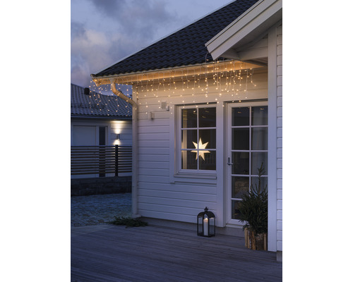 Hausfassade mit Lichterkette, Fensterstern und Laterne für weihnachtliche Dekoration