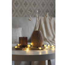 Décoration avec vase, bougeoir et guirlande lumineuse sur une table
