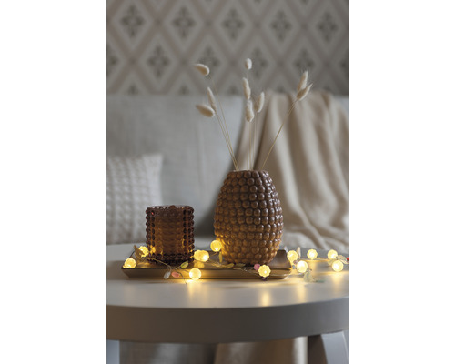 Décoration avec vase, bougeoir et guirlande lumineuse sur une table