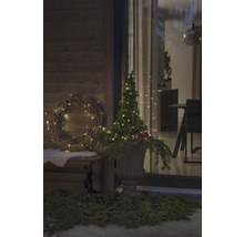 Dekorierte Veranda mit beleuchtetem Kranz und Baum in Vase