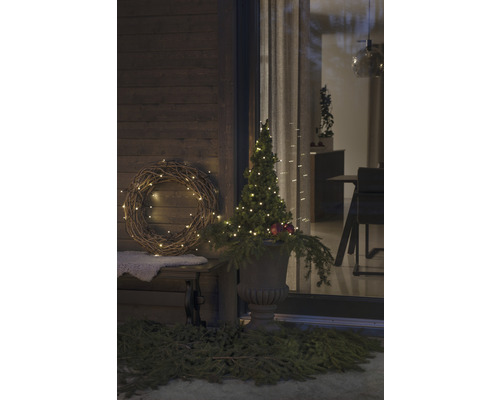 Dekorierte Veranda mit beleuchtetem Kranz und Baum in Vase