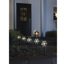 Dekorative Schneeflockenleuchten im Vorgarten eines Hauses mit Kranz an der Tür