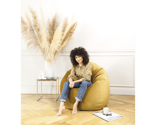 Femme assise sur un pouf jaune dans un salon