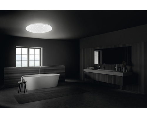 Modernes Badezimmer mit freistehender Badewanne, Waschtisch und runder Deckenleuchte