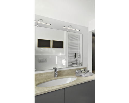 Salle de bain lumineuse avec miroir, lavabo et éclairage