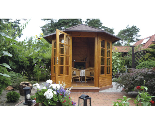Pavillon de jardin en bois avec portes ouvertes et mobilier de jardin dans un écrin de verdure