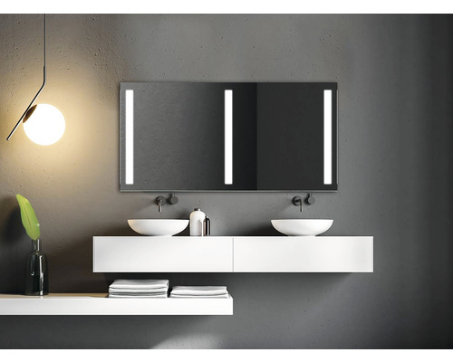 Salle de bain avec lavabos, miroir avec éclairage et serviettes