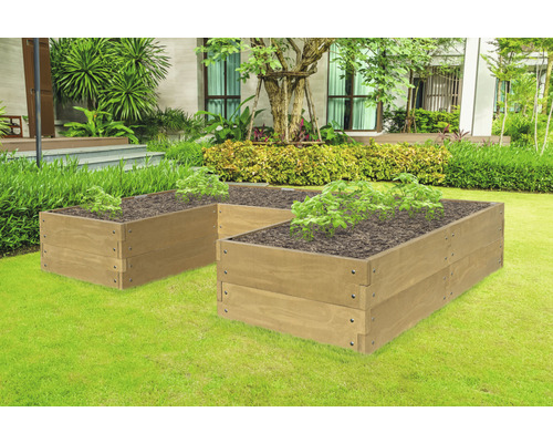 Zwei Hochbeete aus Holz im Garten mit Pflanzen in der Erde.