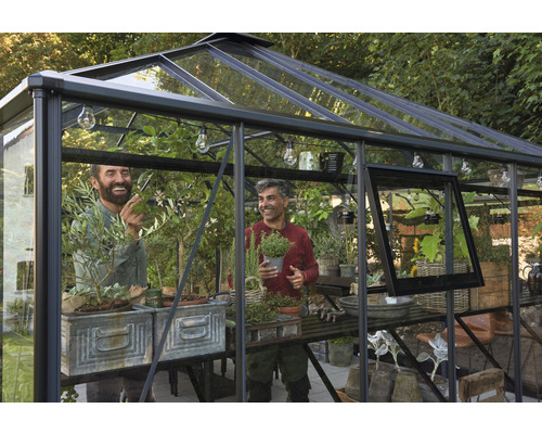 Gewächshaus mit zwei Männern und Pflanzen auf Regalen