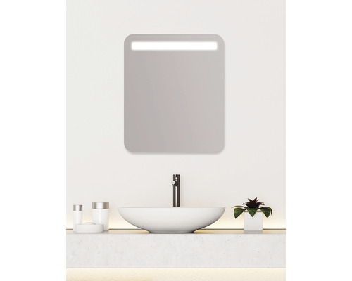 Salle de bains moderne avec miroir éclairé, lavabo et robinet.