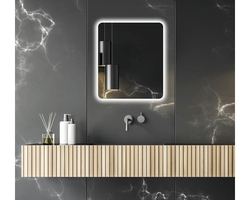 Salle de bain moderne avec miroir lumineux, lavabo et robinetterie sur fond sombre