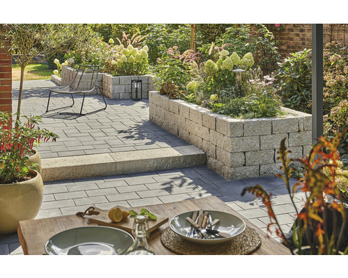 Jardin aménagé avec pavés, coin salon et plates-bandes surélevées