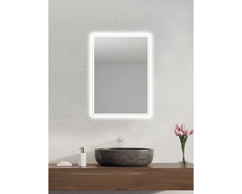 Salle de bains avec miroir lumineux, lavabo et meuble-lavabo