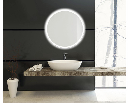 Salle de bain moderne avec miroir rond, lavabo à poser et étagère en pierre naturelle.