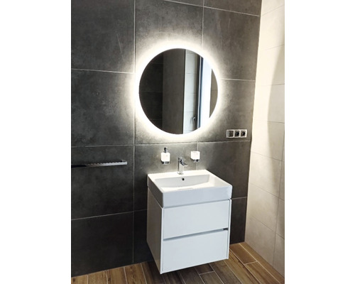 Salle de bains moderne avec miroir éclairé, meuble sous-lavabo et robinetterie