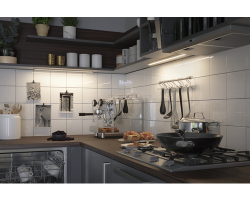 Scène de cuisine avec des ustensiles de cuisine, des appareils et des aliments sur un plan de travail.