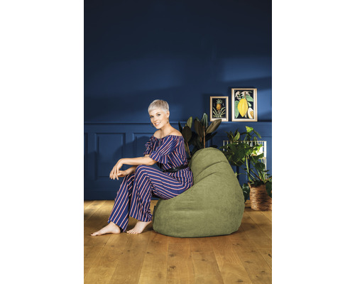 Femme assise sur un pouf vert dans un salon