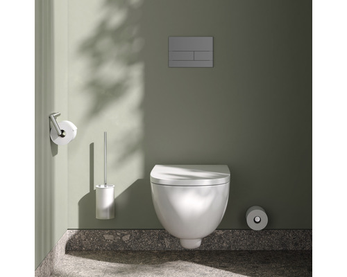 Wandhängendes WC mit Spülkasten, Toilettenbürste und Papierhalter im Badezimmer