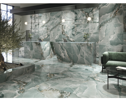 Innenraum mit Boden- und Wandfliesen in Marmoroptik, Rezeption und Sitzecke.