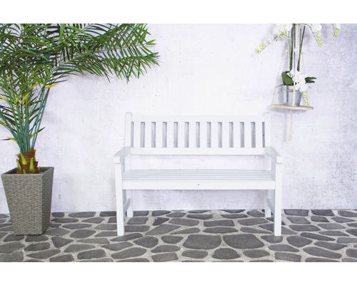 Banc de jardin blanc en bois à côté d''un palmier en pot