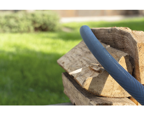 Tuyau d''arrosage sur une pile de bois dans le jardin