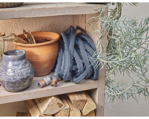 Tuyau d''arrosage sur étagère en bois avec pots et plante