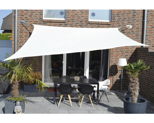 Voile d''ombrage blanche au-dessus d''une terrasse avec table et chaises