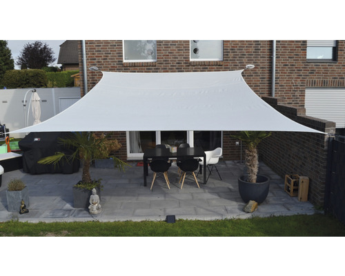 Voile d''ombrage rectangulaire en tissu au-dessus d''une terrasse avec table et chaises
