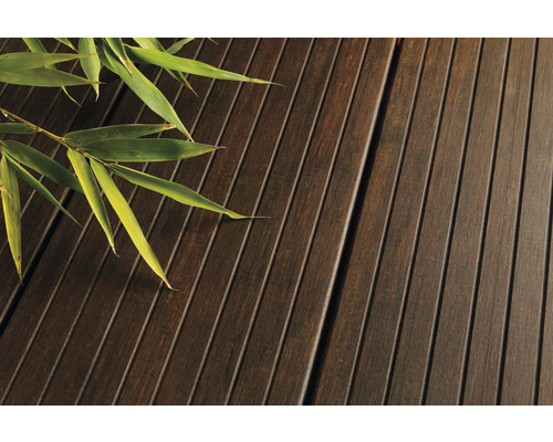 Gros plan de lames de terrasse en bois avec branche de bambou