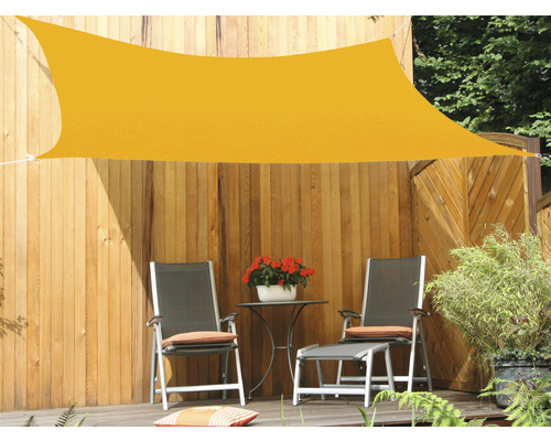 Voile d''ombrage jaune au-dessus d''un salon de jardin sur une terrasse en bois