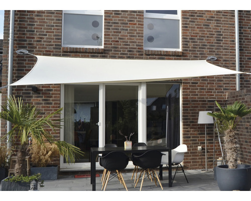 Szene mit Sonnensegel über einem Gartentisch vor einem Haus