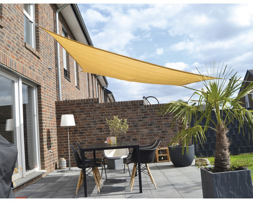 Terrasse mit Sonnensegel, Tisch und Stühlen vor einem Haus