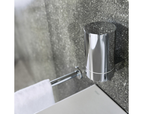 Wandmontierter Zahnputzbecher und Handtuchhalter aus Metall im Badezimmer.