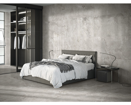 Modernes Schlafzimmer mit Bett, Nachttisch und begehbarem Kleiderschrank vor einer gefliesten Wand