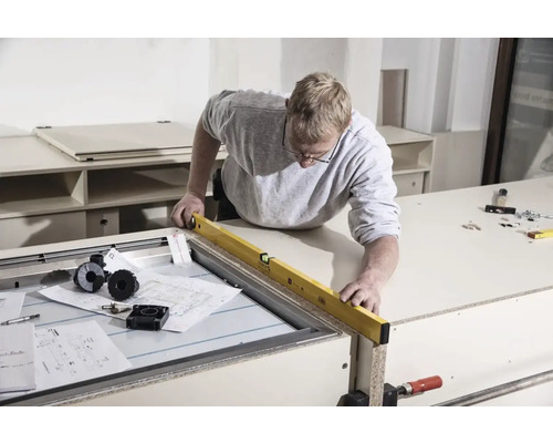 Handwerker benutzt Wasserwaage an Werkbank