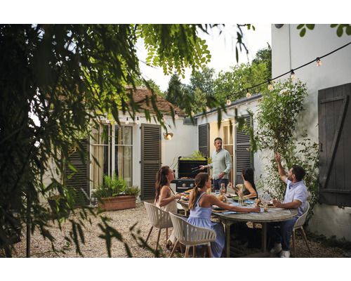 Scène de jardin avec barbecue, table de jardin et plusieurs personnes