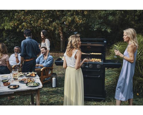 Scène de grillades dans le jardin avec des invités et des plats préparés