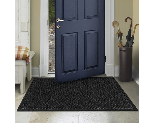 Schwarze Fussmatte vor einer offenen Haustür