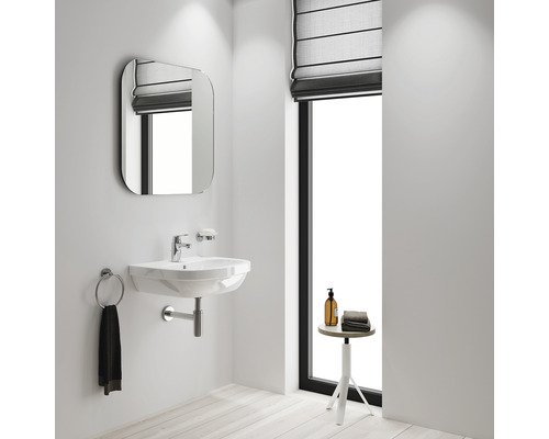 Badezimmer mit Waschbecken, Spiegel, Handtuchhalter, Seifenschale und Fenster