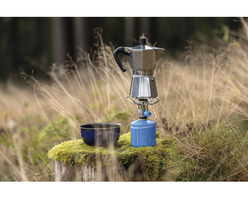 Cafetière italienne sur réchaud à gaz à côté d’un bol en extérieur
