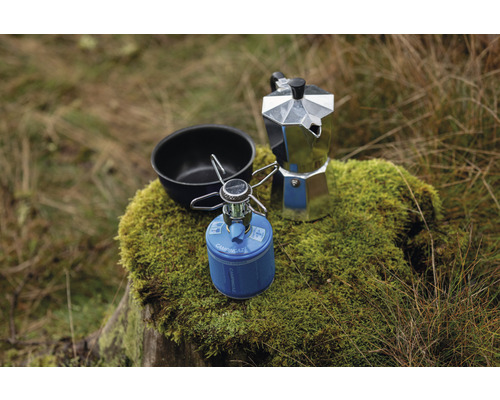 Réchaud de camping, cafetière et bol sur une souche d''arbre