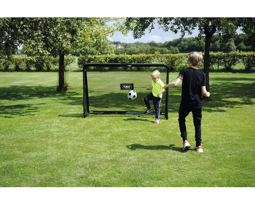 But de football avec deux enfants jouant dans le jardin