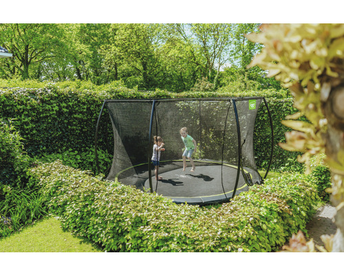 Trampoline avec filet de sécurité dans le jardin avec des enfants