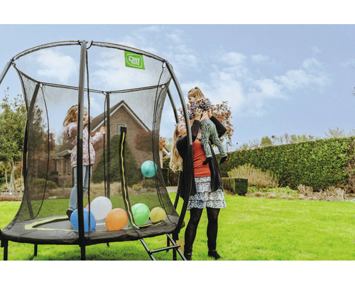 Famille avec un trampoline de jardin rond avec filet de sécurité sur une pelouse.