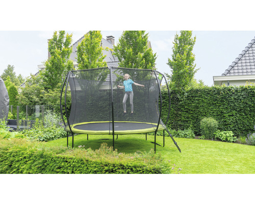 Mädchen springt auf einem Gartentrampolin mit Sicherheitsnetz