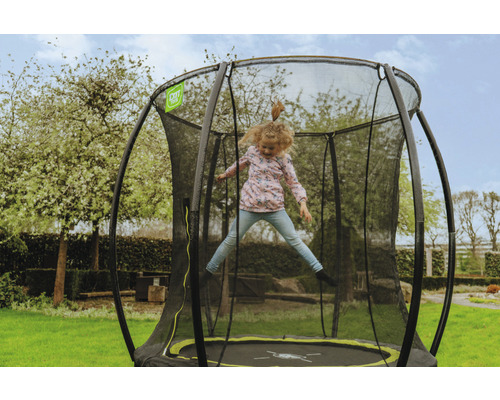 Fille sautant sur un trampoline de jardin avec filet de sécurité